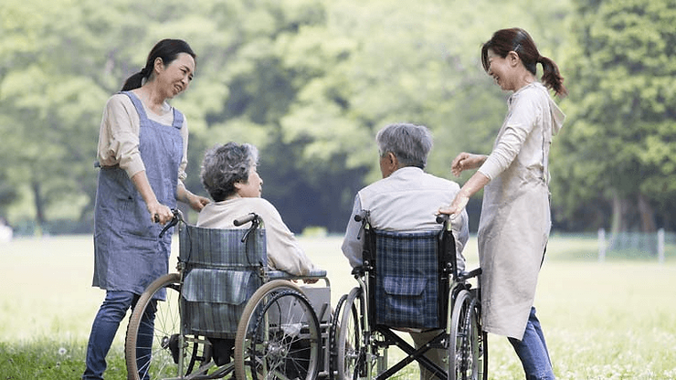 老人ホームに入居している夫婦と談笑する介護職員